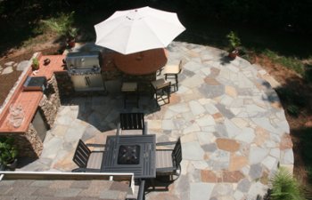 backyard stone patio with an outdoor kitchen