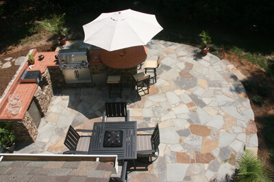 backyard stone patio with an outdoor kitchen