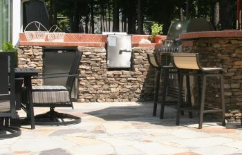 Stone patio with chairs and barbecue