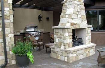 A patio with an outdoor kitchen and fireplace.